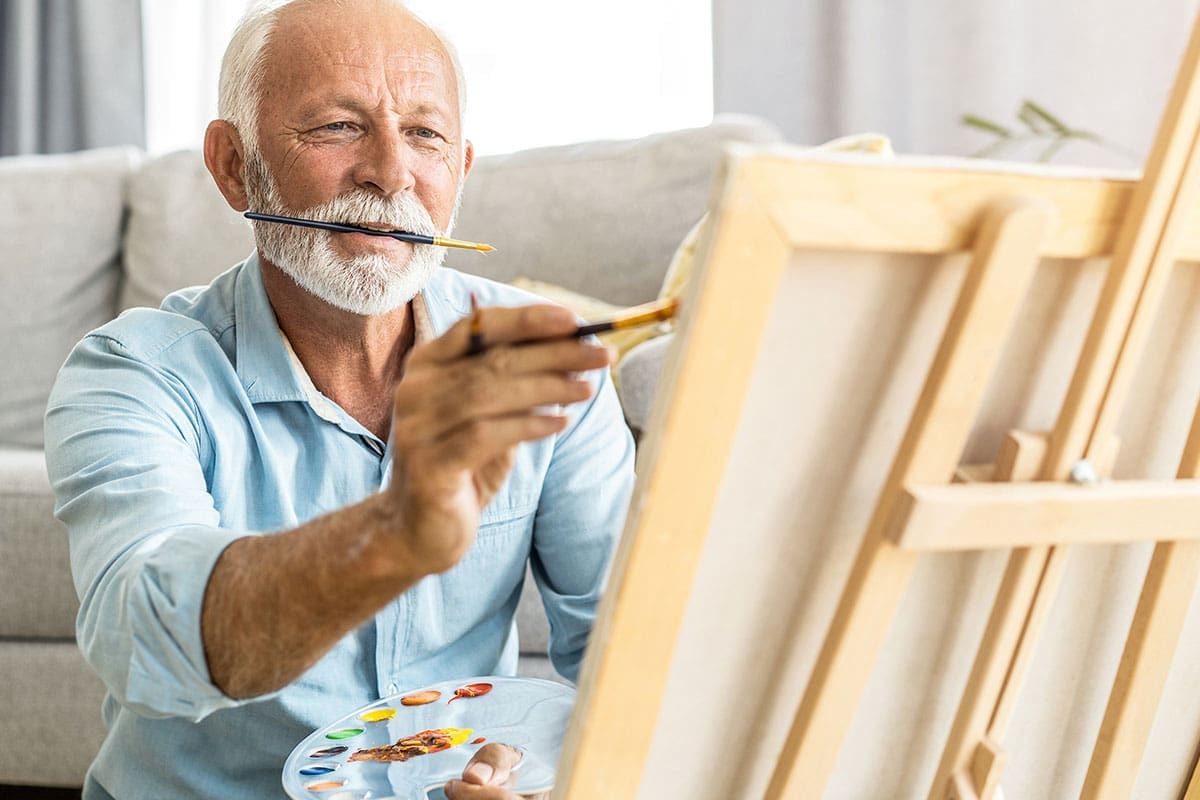 Senior man painting on a canvas