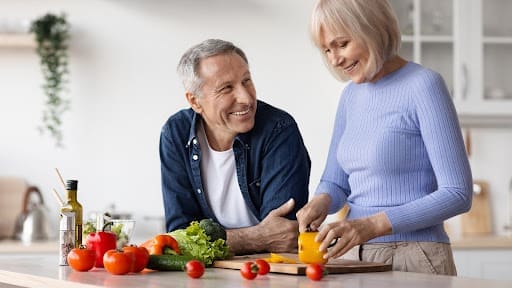older couple making healthy snacks for senior at home